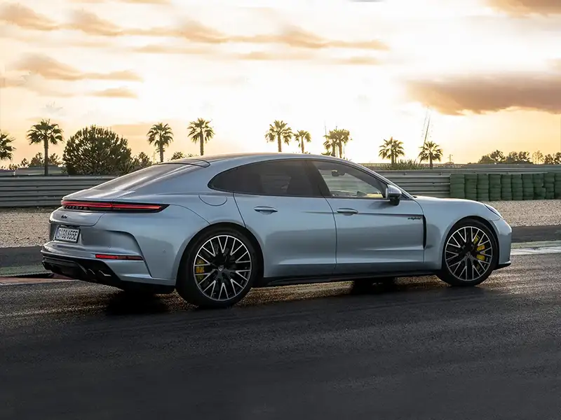 Porsche Panamera Turbo E-Hybrid plata vista trasera lateral en circuito al atardecer